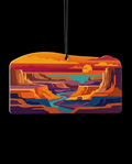 A rectangular car air freshener ornament with rounded corners, featuring a colorful graphic illustration of a canyon landscape at sunset, suspended by a black string against a solid black background.