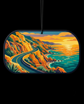 A dog tag-shaped car air freshener featuring a stylized coastal landscape illustration with a winding road, orange cliffs, and turquoise water at sunset, shown against a black background.