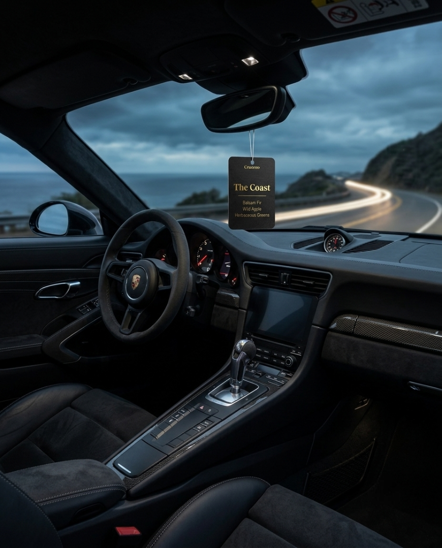 Car interior with a 'The Coast' air freshener hanging from the rearview mirror.