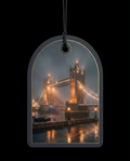 An arched hanging ornament or tag with a printed nighttime view of Tower Bridge in London, suspended by a black cord against a black background.