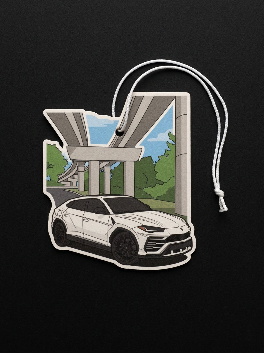 A die-cut car-shaped air freshener or charm featuring a white SUV under an elevated highway overpass, with a white hanging string, shown on a black background.